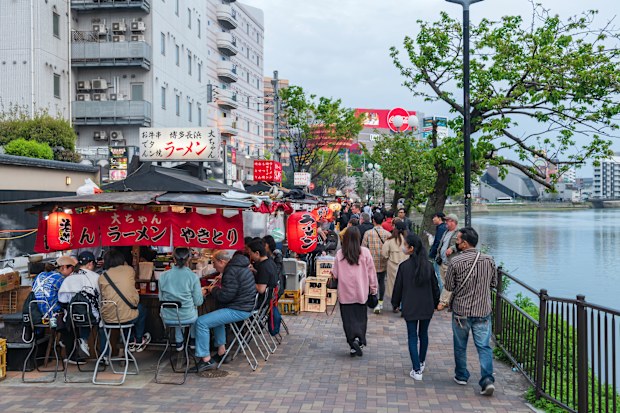 Fukuoka, Japan - April 7, 2024: People at Yatai food stalls along Naka river near Canal city Hakata. Famous landmark for best street dinner food in Fukuoka