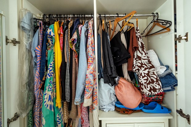 Messy closet in bedroom overstuffed with clothes