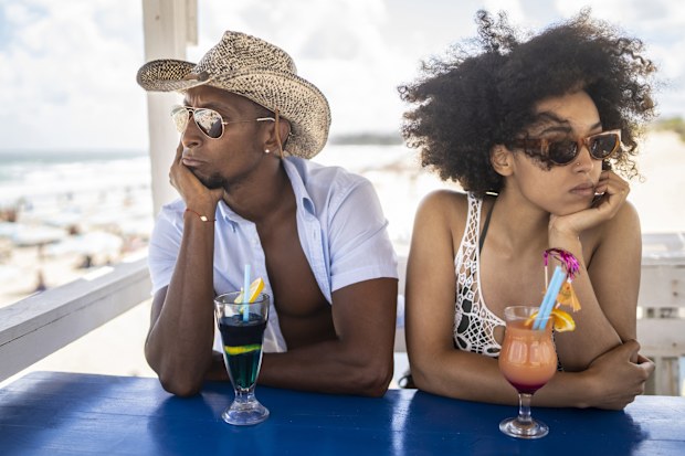 Couple arguing each other during their vacation. They are standing bored and don't speak to each other