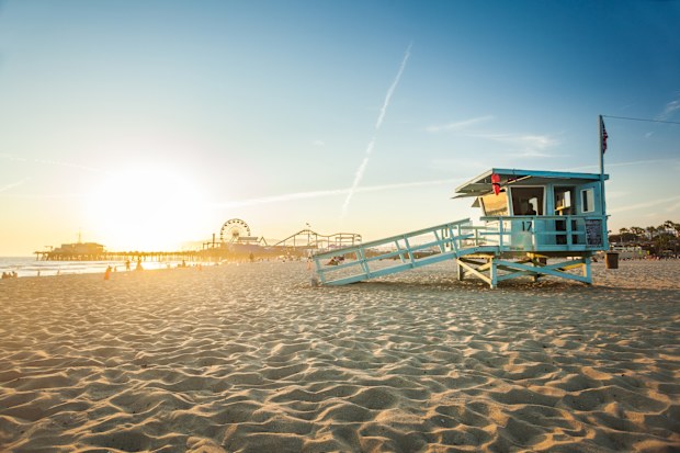 Sunset on Santa Monica beach with rescue cabin and amusement park on the background