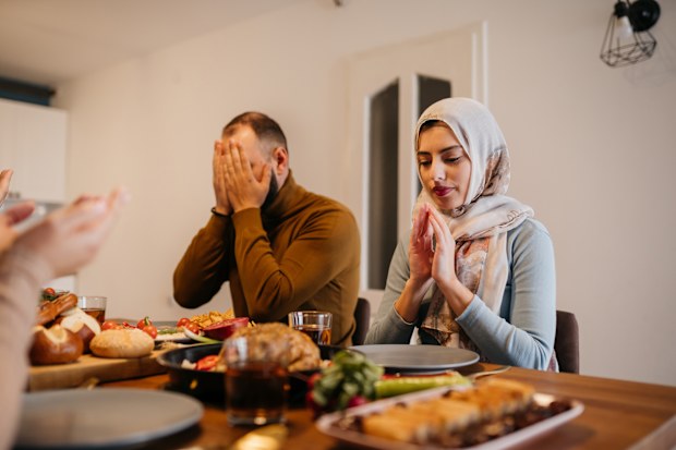 Traditional Muslim family sharing pita bread during dinner on Ramadan