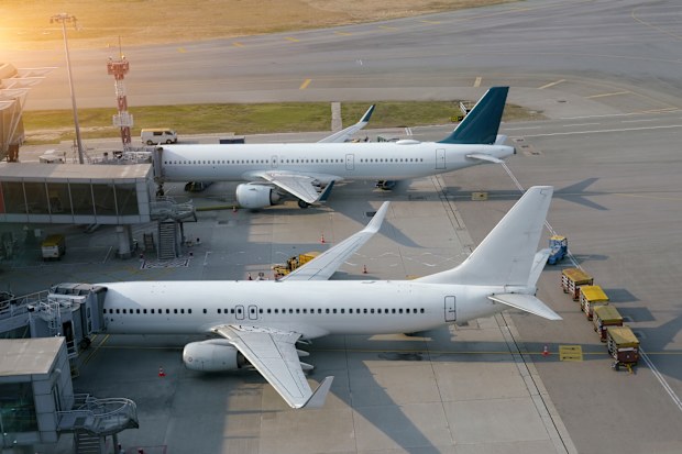 Two passenger planes connected by a jet bridge undergo maintenance after the aircraft's arrival at a large aviation hub