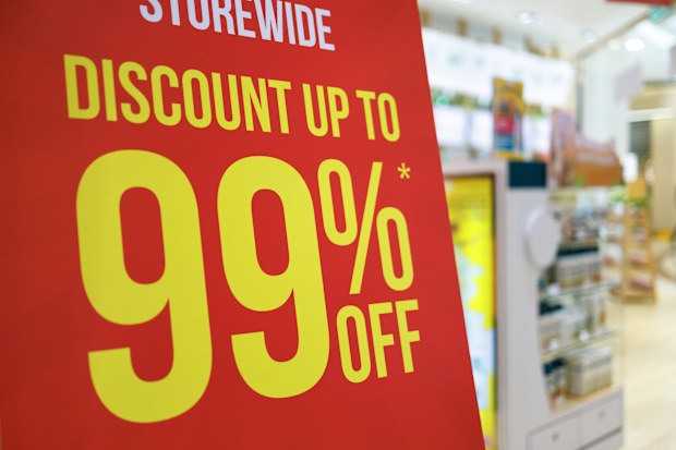 Bold red and yellow store signage promoting discount up to 99% off on selected items during a storewide sales event.