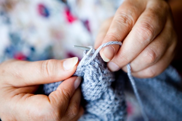 Close-up view of hands knitting.