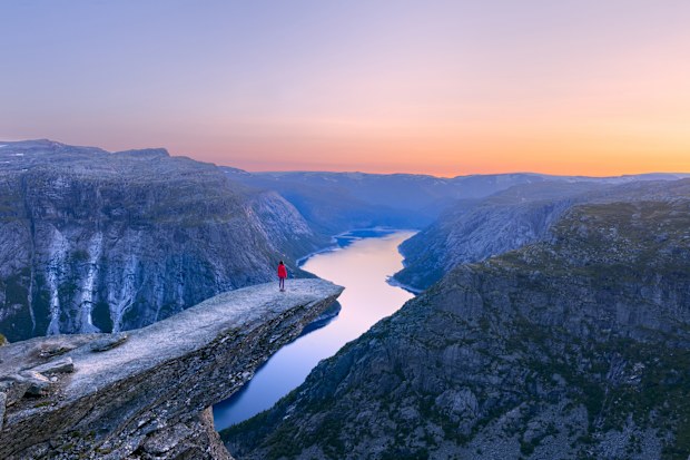 Alone tourist on Trolltunga rock - most spectacular and famous scenic cliff in Norway - Landscape