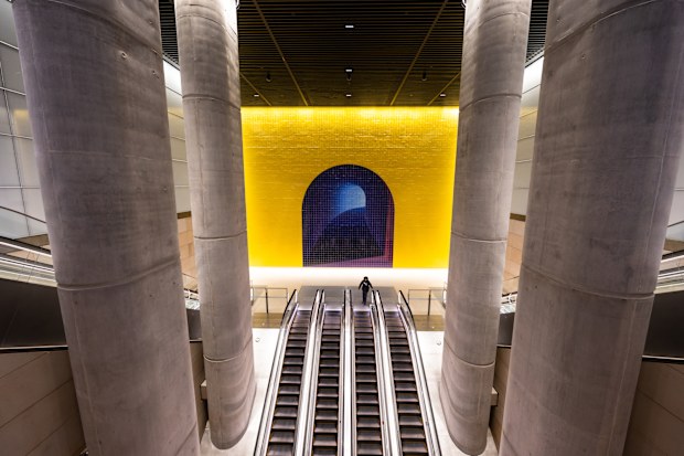 Sydney, Australia - August 22, 2024: Escalator view with yellow tiled wall at Gadigal Station.