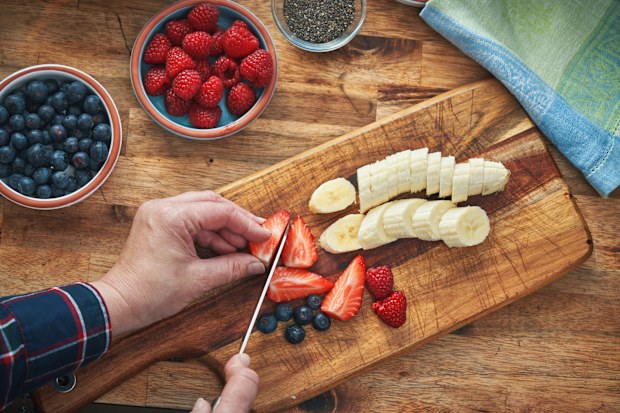 person chopping strawberries 
