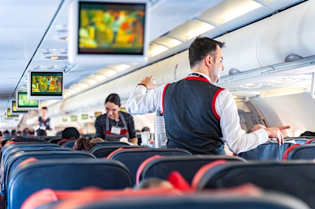 Air hostess serving food and drinks onboard in turkish airline flight