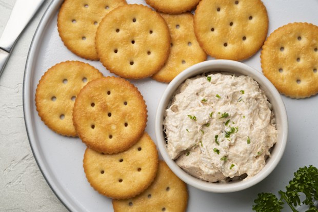 Tuna spread in white bowl with Butter cracker in white plate.Top view