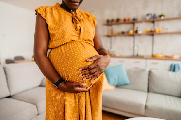 Pregnant woman holding her belly at home