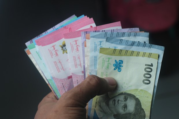 hand holding rupiah, Indonesian currency