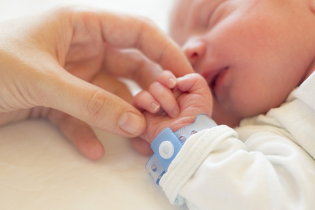 Baby boy wearing hospital bracelet, newborn