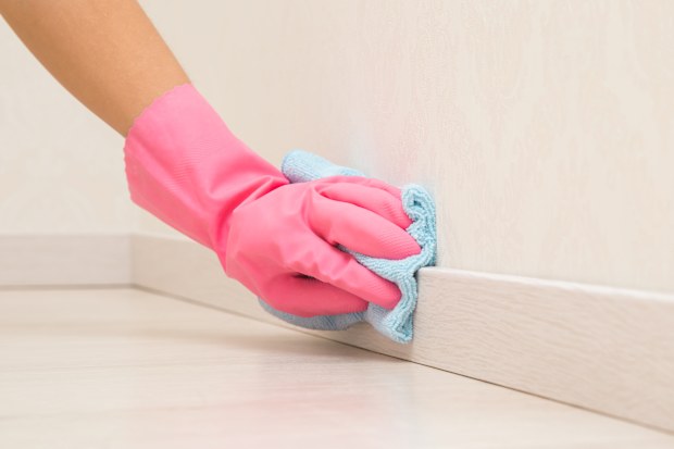 wiping skirting board with a cloth, cleaning