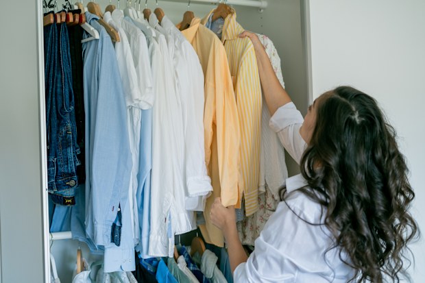 woman is sorting things in large spacious closet. Home organization. Washing things.