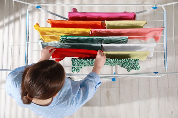 Woman hanging different apparel on clothes airer