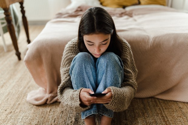 Stock photo of teenager using smartphone