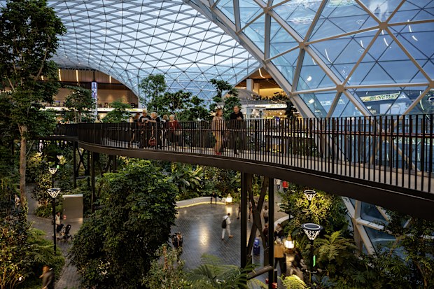 Doha, Qatar - April 09, 2024: Massive glass dome and elevated walkway above indoor garden at the Orchard at Doha's Hamad International Airport