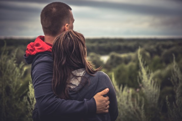 Young couple man woman together embracing looking with hope into the distance concept love hope togetherness