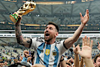Argentina's Lionel Messi celebrates with the trophy in front of the fans after winning the World Cup final soccer match between Argentina and France at the Lusail Stadium in Lusail, Qatar, Sunday, Dec. 18, 2022. Argentina won 4-2 in a penalty shootout after the match ended tied 3-3.