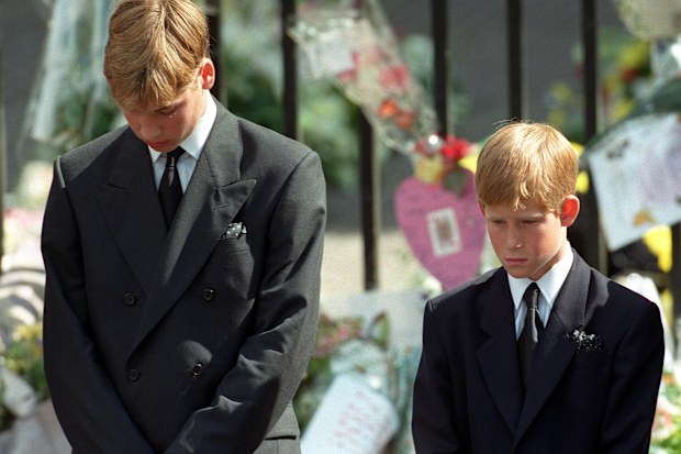 Prince William (left) and Prince Harry (right), the sons of Diana, Princess of Wales, bow their heads as their mother's coffin is taken out of Westminster Abbey following her funeral service. 6/9/1997