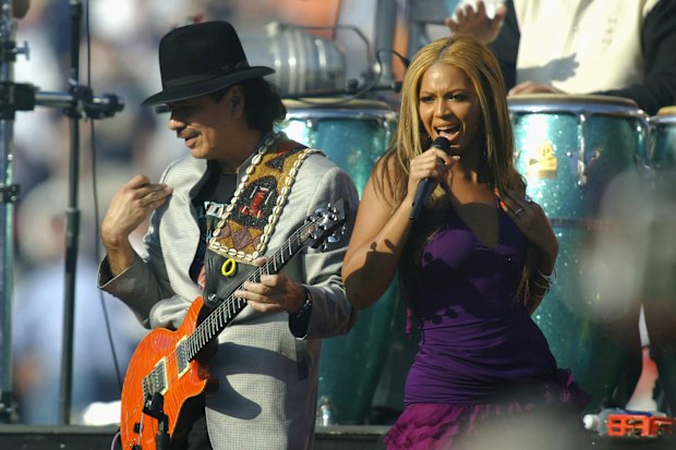 SAN DIEGO - JANUARY 26:  Carlos Santana (L) performs with Beyonce Knowles of Destiny's Child (R) before the start of Super Bowl XXXVII between the Tampa Bay Buccaneers and the Oakland Raiders on January 26, 2003 at Qualcomm Stadium in San Diego, California. (Photo by Donald Miralle/Getty Images)
