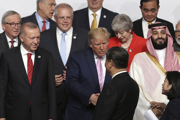 Prime Minister Scott Morrison looks on as President of the United States Donald Trump and President of China Xi Jinping shake hands during the 'family photo' at the G20 Summit in Osaka, Japan, in 2019.