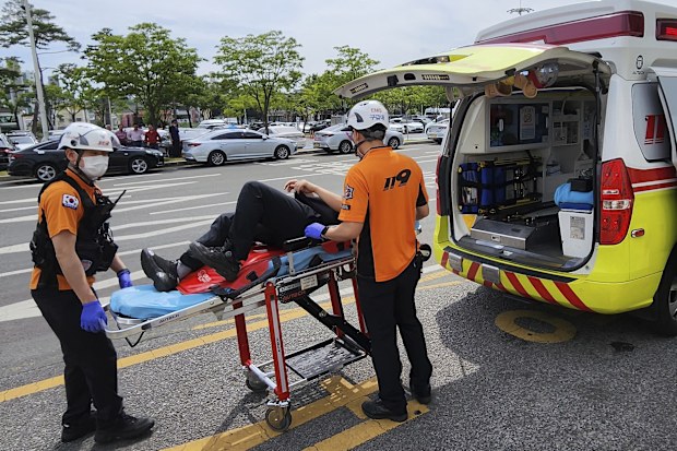 Rescue workers move a passenger on a stretcher to an ambulance at Daegu International Airport in Daegu, South Korea, Friday, May 26, 2023.  