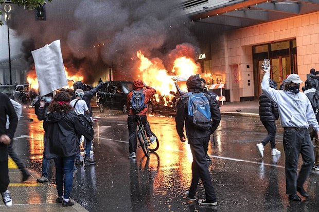 People set fire to vehicles during a protest in Seattle.