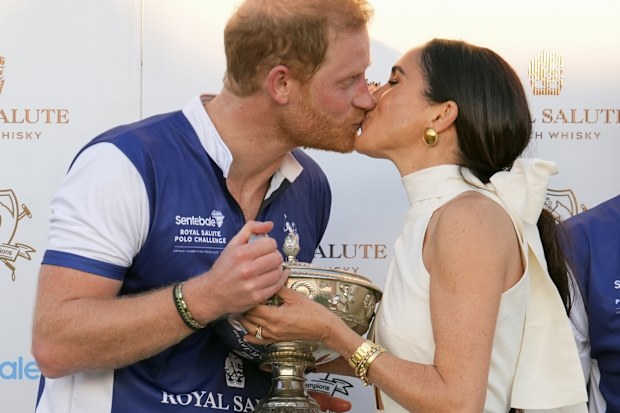 Prince Harry and Meghan Markle, Duchess of Sussex, kiss as she presents his polo team with the trophy for winning the Royal Salute Polo Challenge to Benefit Sentebale, Friday, April 12, 2024, in Wellington, Florida