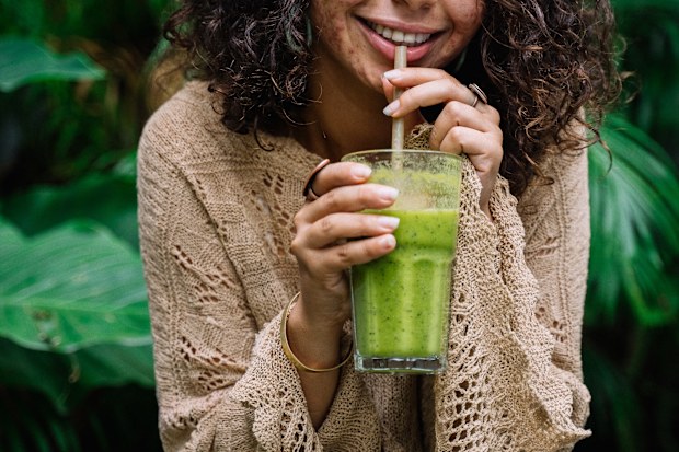 Stock photo: woman smiling with a juice and acne on her skin.