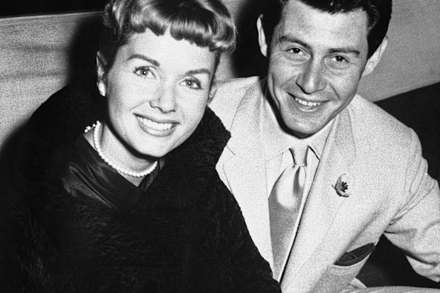 File- This June 4, 1957, file photo shows Eddie Fisher and his wife Debbie Reynolds attending the reception at the Prince of Wales Theater, London. Reynolds herself has likened their split to the Jennifer Aniston-Angelina Jolie-Brad Pitt triangle, telling Vanity Fair last year: "My three husbands all left me for another woman and obviously I wasn't a very sexual lady."  (AP Photo/File)