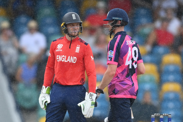 Jos Buttler of England and Michael Jones of Scotland leave the field as rain stops play during the ICC Men's T20 Cricket World Cup match at Kensington Oval.