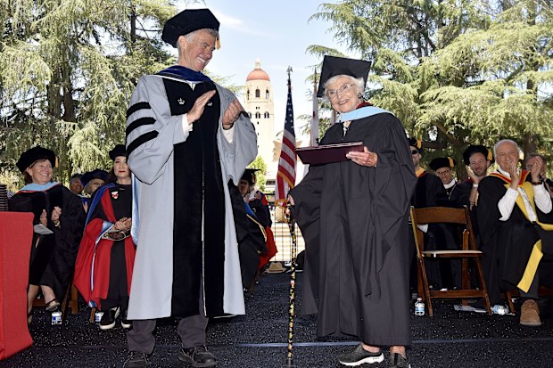 Virginia Hislop accepts her diploma for her master of arts in education at Stanford University's 2024 Graduate School of Education commencement ceremony from Dean Dan Schwartz.