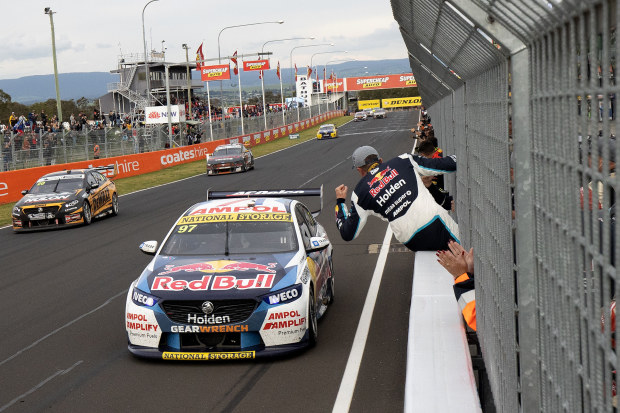 Garth Tander leans over the concrete wall to celebrate after winning with co-driver Shane van Gisbergen in the 2020 Bathurst 1000.
