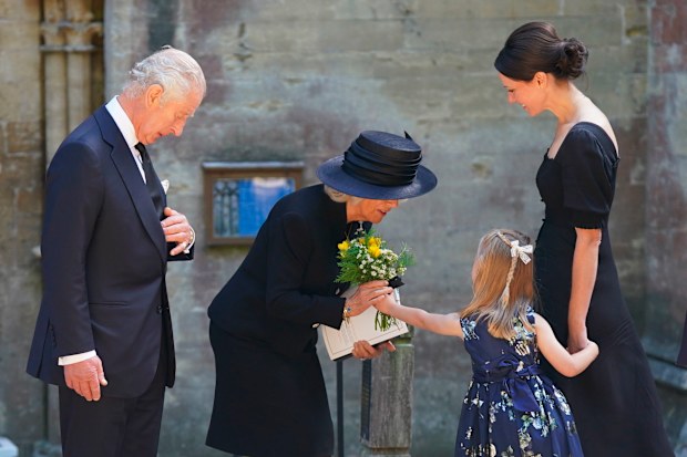 Britain's King Charles III and Camilla, the Queen Consort receive a bouquet from a girl as they leave the Llandaff Cathedral following a Service of Prayer and Reflection for the life of Queen Elizabeth II.
