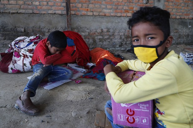 Children of Nepalese daily wage workers rest at a makeshift shelter after being stopped by policemen while they were on their way to their village, during lockdown to prevent the spread of COVID-19 in Lubu, on the outskirts of Lalitpur, Nepal.