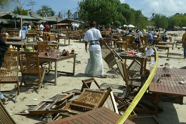 A man starts cleaning up on Jimbaran beach following the 2005 Bali bombings.