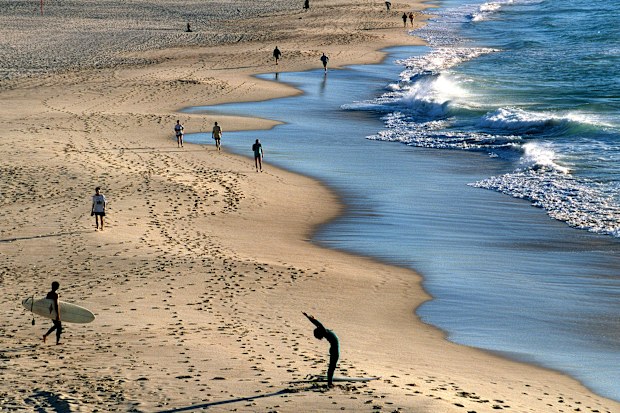 daylight saving:981020.smh.news.photograph:steven siewert bondi beach at sunrise.life begins with the sun rising at around 5am with crowds making the most of the early light which will begin an hour later as of sunday.