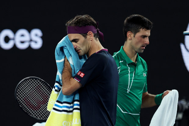 MELBOURNE, AUSTRALIA - JANUARY 30: Novak Djokovic of Serbia walks past Roger Federer of Switzerland during change of ends in their Men's Singles Semifinal match on day eleven of the 2020 Australian Open at Melbourne Park on January 30, 2020 in Melbourne, Australia. (Photo by Clive Brunskill/Getty Images)