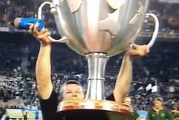 All Blacks captain Sean Fitzpatrick struggles to hoist the original, oversized Tri Nations trophy.