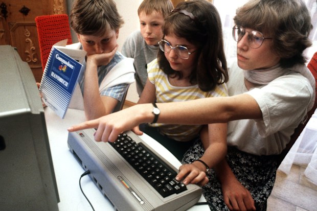 Adolescents try out a Commodore 64 in Nuremberg in May 1985. (Photo by Karl Staedele/picture alliance via Getty Images)