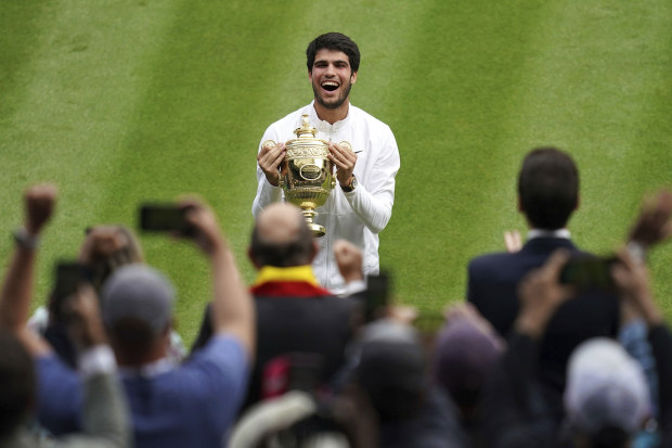 Spain's Carlos Alcaraz celebrates with the trophy after beating Serbia's Novak Djokovic to win the final of the mens singles at Wimbledon.