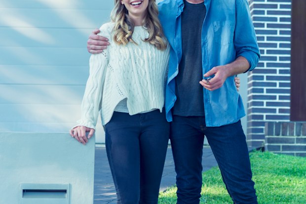 Young couple in front of home