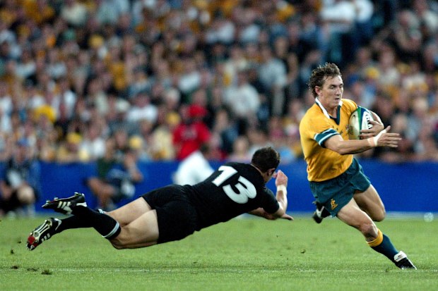 Mat Rogers beats the tackle of Leon MacDonald in the 2003 Rugby World Cup semi-final.