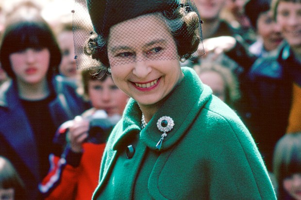 Worcester, England, in 1980, Queen Elizabeth wears the Round Cambridge Emerald brooch, which belonged to her great-grandmother, Princess Mary Adelaide of Cambridge, Duchess of Teck.