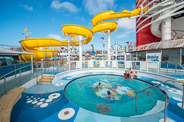 An outdoor circular pool and yellow water slide