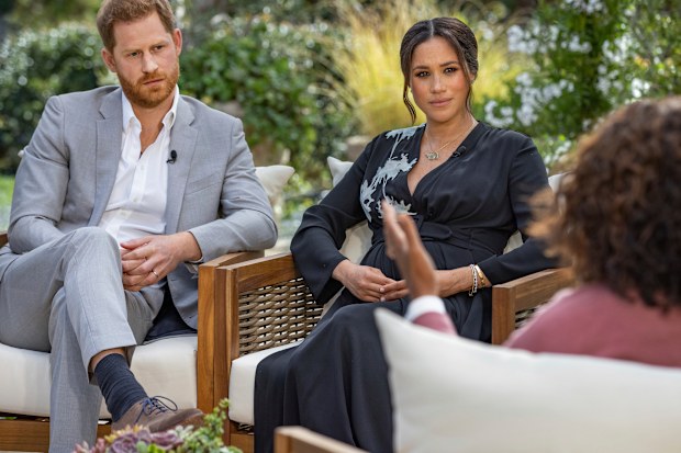 This image provided by Harpo Productions shows Prince Harry, from left, and Meghan, The Duchess of Sussex, in conversation with Oprah Winfrey. (Joe Pugliese/Harpo Productions via AP)