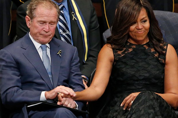 Michelle Obama holds former President George Bush's hand at memorial for five Dallas and DART police officers shot to death in 2016