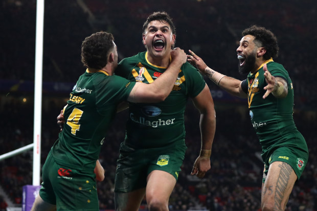 Latrell Mitchell of Australia celebrates with teammates Nathan Cleary and Josh Addo-Carr after scoring their team's sixth try during the Rugby League World Cup Final match between Australia and Samoa at Old Trafford on November 19, 2022 in Manchester, England. (Photo by George Wood/Getty Images)