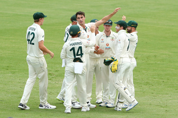Pat Cummins of Australia celebrates with team mates after dismissing Shubman Gill of India.